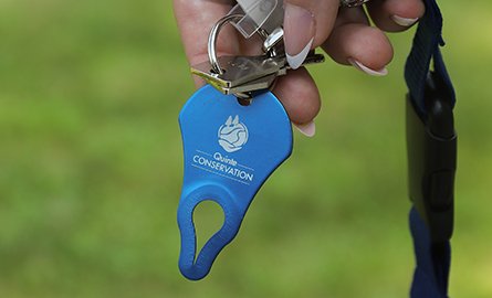 A dark blue tick key with the Quinte Conservation logo.